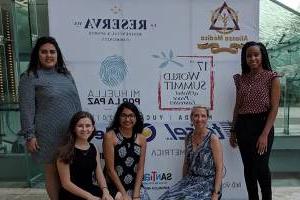 Students wth Dr. Cooke in front of world summit banner